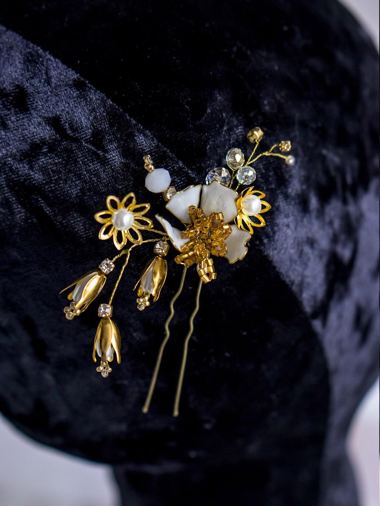 Bridal hairstyle with gold flower hair pins and braided details.