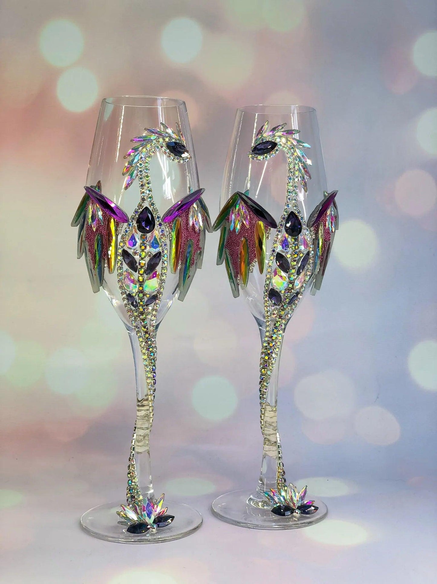 Two ornate dragon-themed wineglasses standing tall, accentuated with gleaming jewel-like details; set against a soothing gradient of teal and muted lavender.