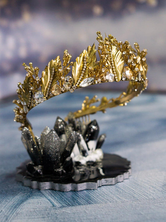 Gold Wedding Crown with Leaves and Crystals on stand on blue background