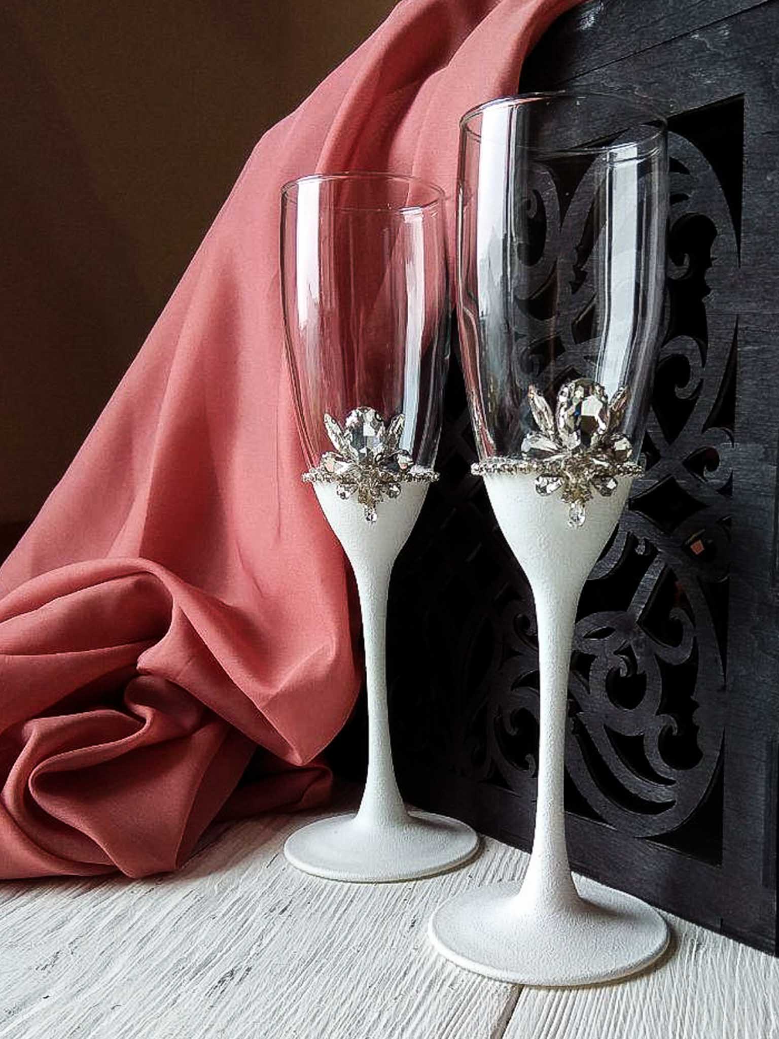 Elegant white champagne flutes and silver cake server