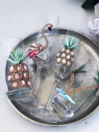 Crystal wine glass with an ornate rose gold pineapple decoration, reflecting light beautifully.