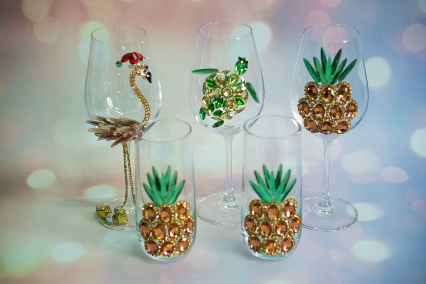 Close-up of a handcrafted wine glass with a detailed rose gold pineapple design, showcasing artisan skill.