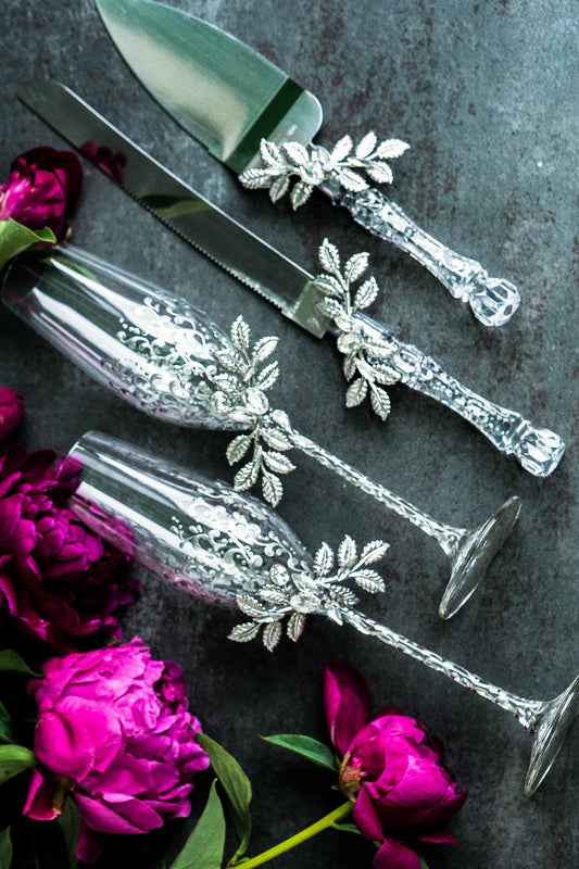 Elegant silver wedding champagne glasses and cake cutting set