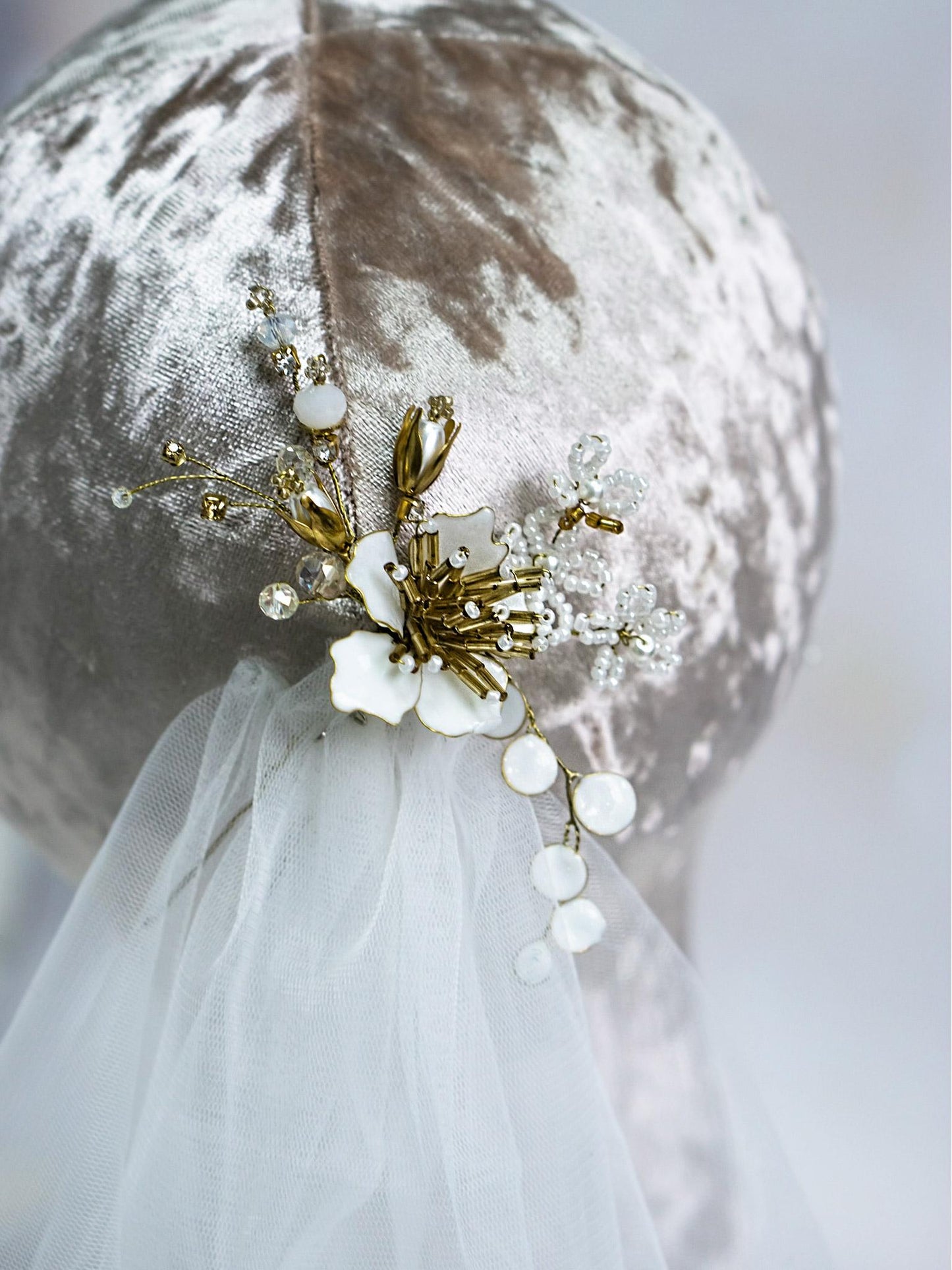 Bride's updo with gold flower hair pin featuring spikelets made of crystal beads