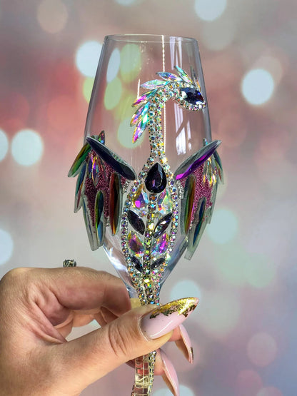 A close-up view showcasing the shimmering detail of a dragon's wing, adorned with gleaming gemstones on the body of the wineglass.