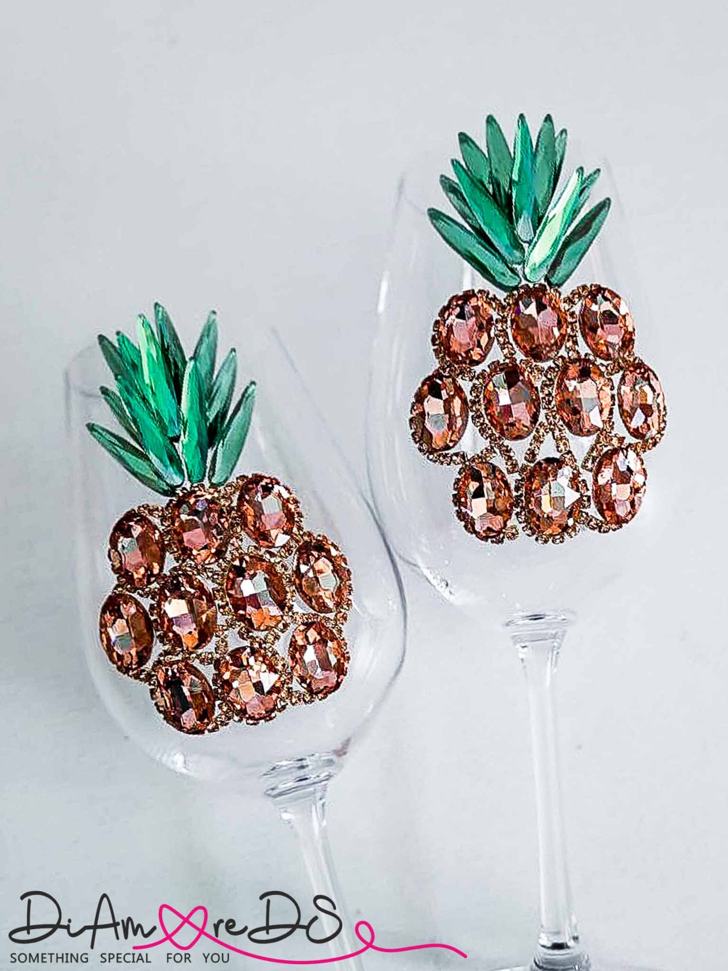 Elegant rose gold pineapple wine glass with sparkling crystal embellishments on a white backdrop.