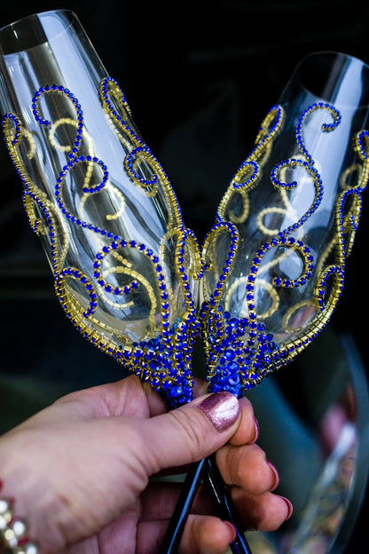 Luxurious gold and royal blue custom champagne glasses for weddings.