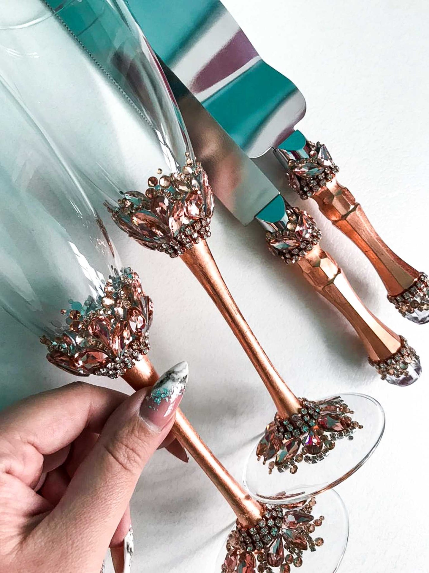 Rose gold-themed wedding champagne glasses and cake utensils