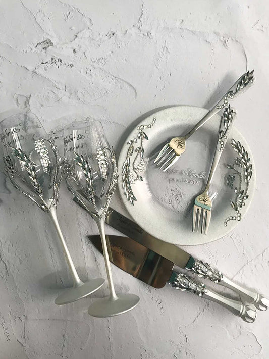 Elegant wedding cake cutting set,  champagne glasses, and a dessert plate with rhinestone chain details