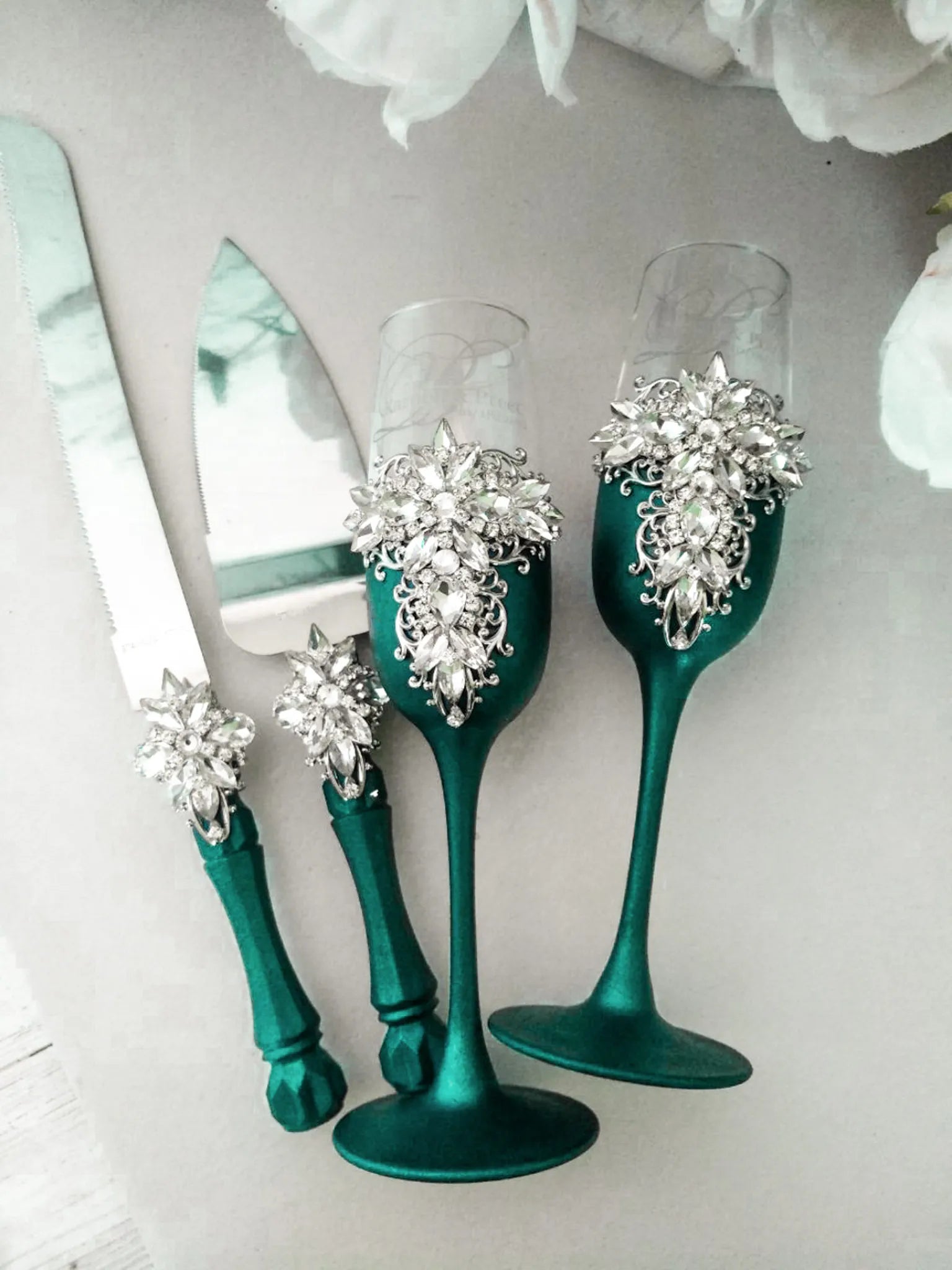 Elegant wedding toasting flutes adorned with emerald detailing