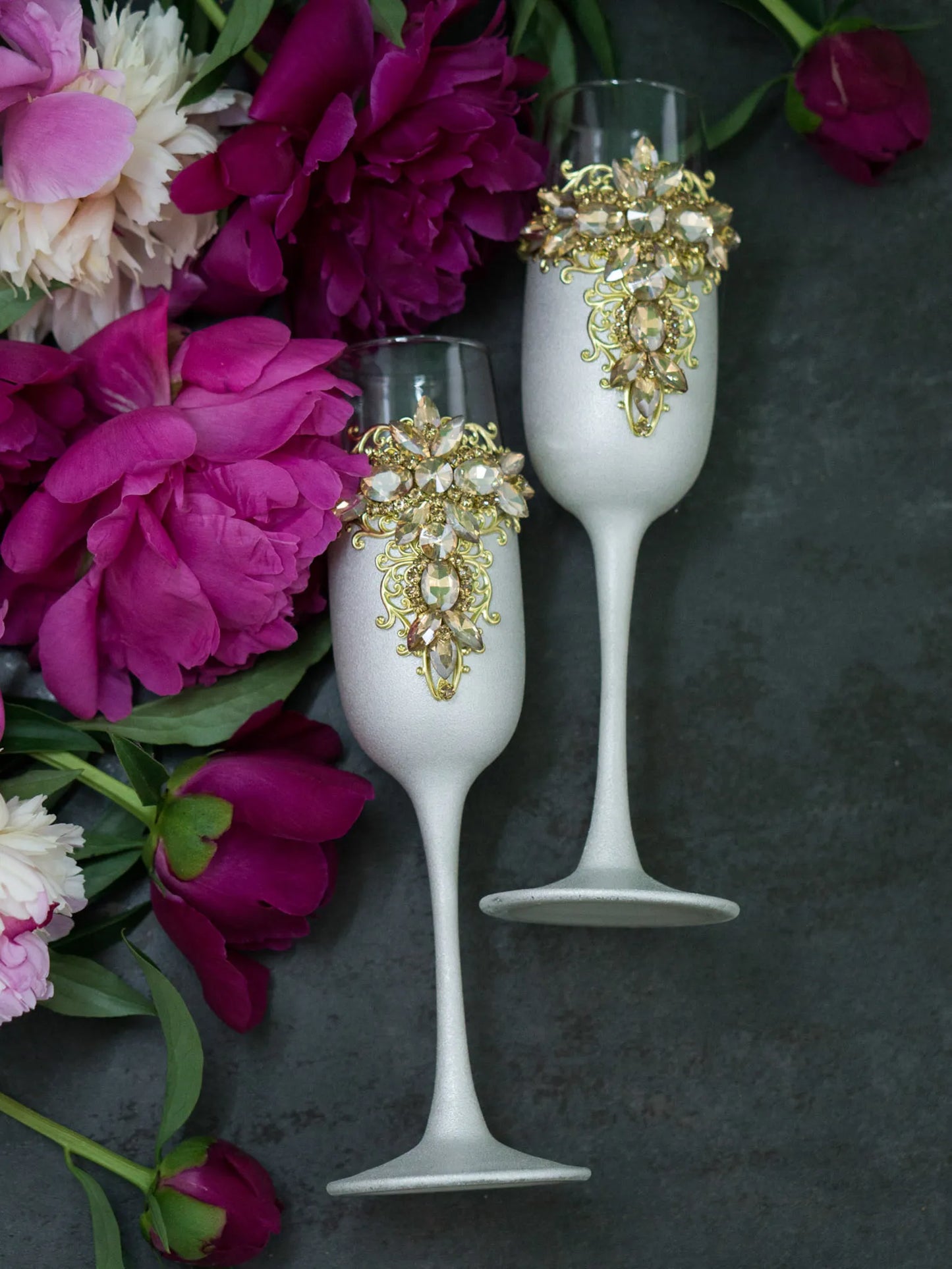 Elegant toasting glasses featuring intricate gold filigree