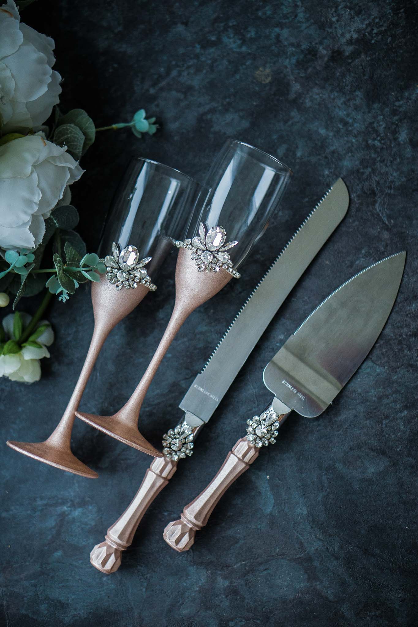 Artisan-crafted rose gold wedding toasting flutes and cake server