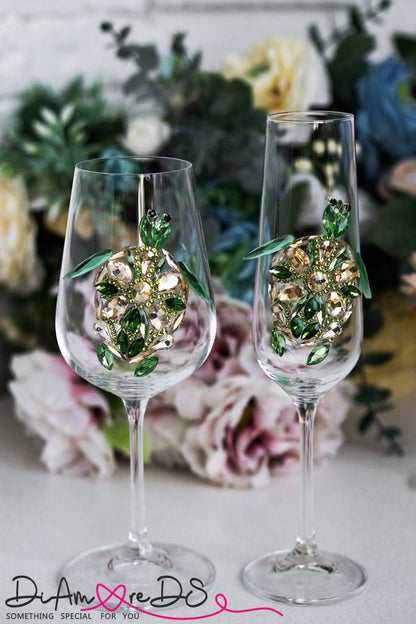 A series of ornate wine glasses with detailed bejeweled animal designs, standing tall against a bouquet of flowers.