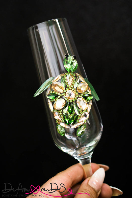 Handcrafted champagne flute with a delicate sea turtle design, adorned with green and gold crystals.