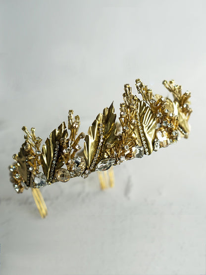 Gold wedding crown with leaves and crystals on white background, view from the right side"