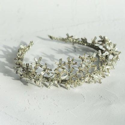 Daisy silver flower tiara on white background viewed from above